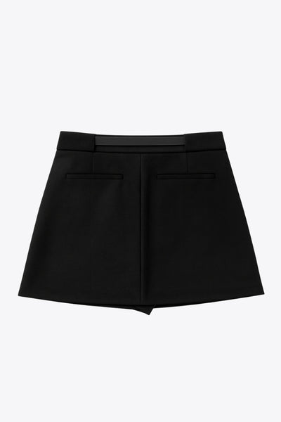 Falda short corto de fit recto, cintura alta con pretina y trabillas, vivos decorativos posteriores, cierre frontal con broche y cremallera ocultos. Detalle de cinturón en contraste con hebilla.