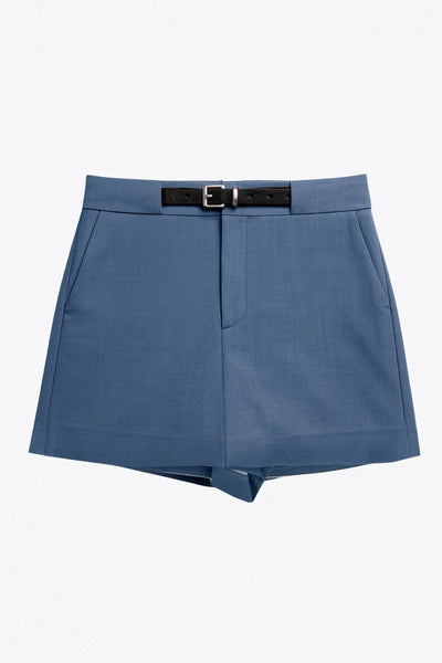 Falda short corto de fit recto, cintura alta con pretina y trabillas, vivos decorativos posteriores, cierre frontal con broche y cremallera ocultos. Detalle de cinturón en contraste con hebilla.