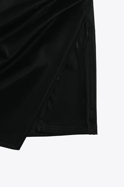 Falda short corto de efecto piel, fit ajustado, cintura alta elástica, cruce frontal asimétrico y plisados decorativos laterales.