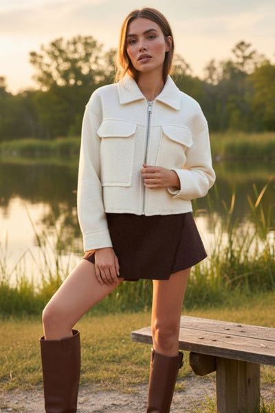 Falda short de fit ajustado, cintura alta, cruce frontal asimétrico, vivos decorativos posteriores y cierre lateral con cremallera oculta.