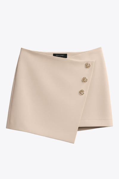 Falda short corto de fit ajustado, cintura alta, cruce frontal con nudo y plisados decorativos frontales. Cierre posterior con cremallera oculta.