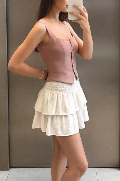 Falda short de corte en a, cintura alta elástica con pretina fruncida y capas de olanes en bajo.