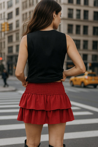 Falda short de corte en a, cintura alta elástica con pretina fruncida y capas de olanes en bajo.