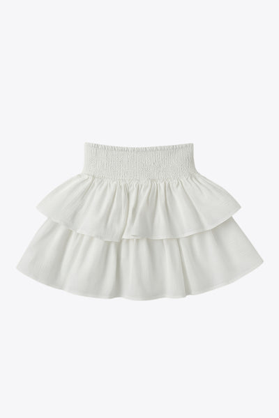 Falda short de corte en a, cintura alta elástica con pretina fruncida y capas de olanes en bajo.