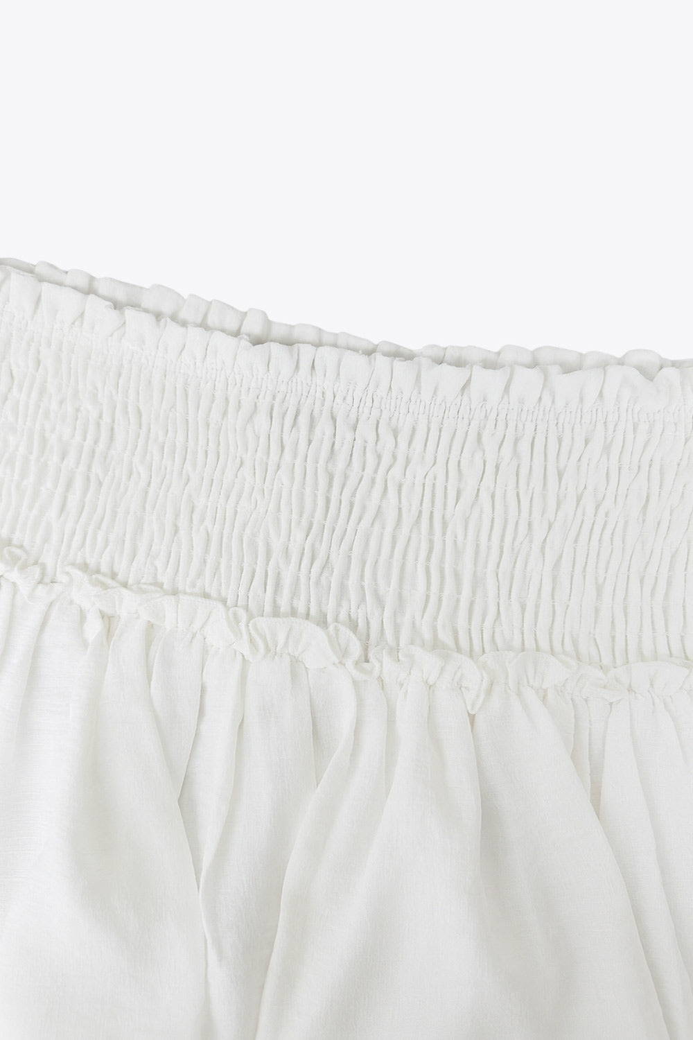 Falda short de corte en a, cintura alta elástica con pretina fruncida y capas de olanes en bajo.