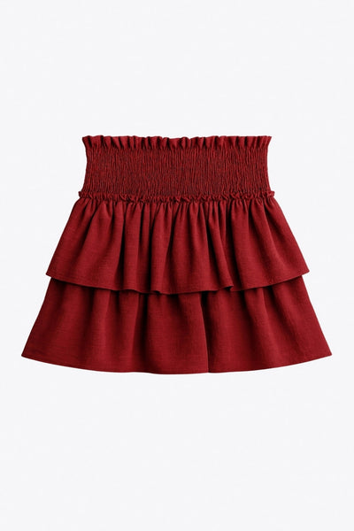 Falda short de corte en a, cintura alta elástica con pretina fruncida y capas de olanes en bajo.