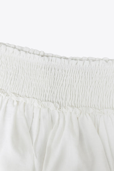 Falda short de corte en a, cintura alta elástica con pretina fruncida y capas de olanes en bajo.