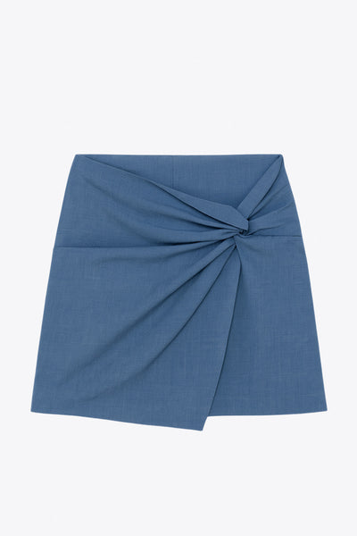 Falda short corto de fit ajustado, cintura alta, cruce frontal con nudo y plisados decorativos frontales. Cierre posterior con cremallera oculta.
