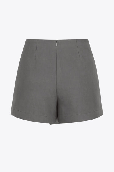 Falda short corto de fit ajustado, cintura alta, cruce frontal con nudo y plisados decorativos frontales. Cierre posterior con cremallera oculta.