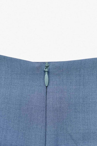 Falda short corto de fit ajustado, cintura alta, cruce frontal con nudo y plisados decorativos frontales. Cierre posterior con cremallera oculta.