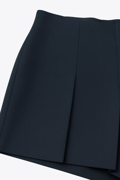 Falda short corto de cintura alta con pinzas y tableado frontal, corte en a, vivos decorativos posteriores y cierre lateral con cremallera oculta.