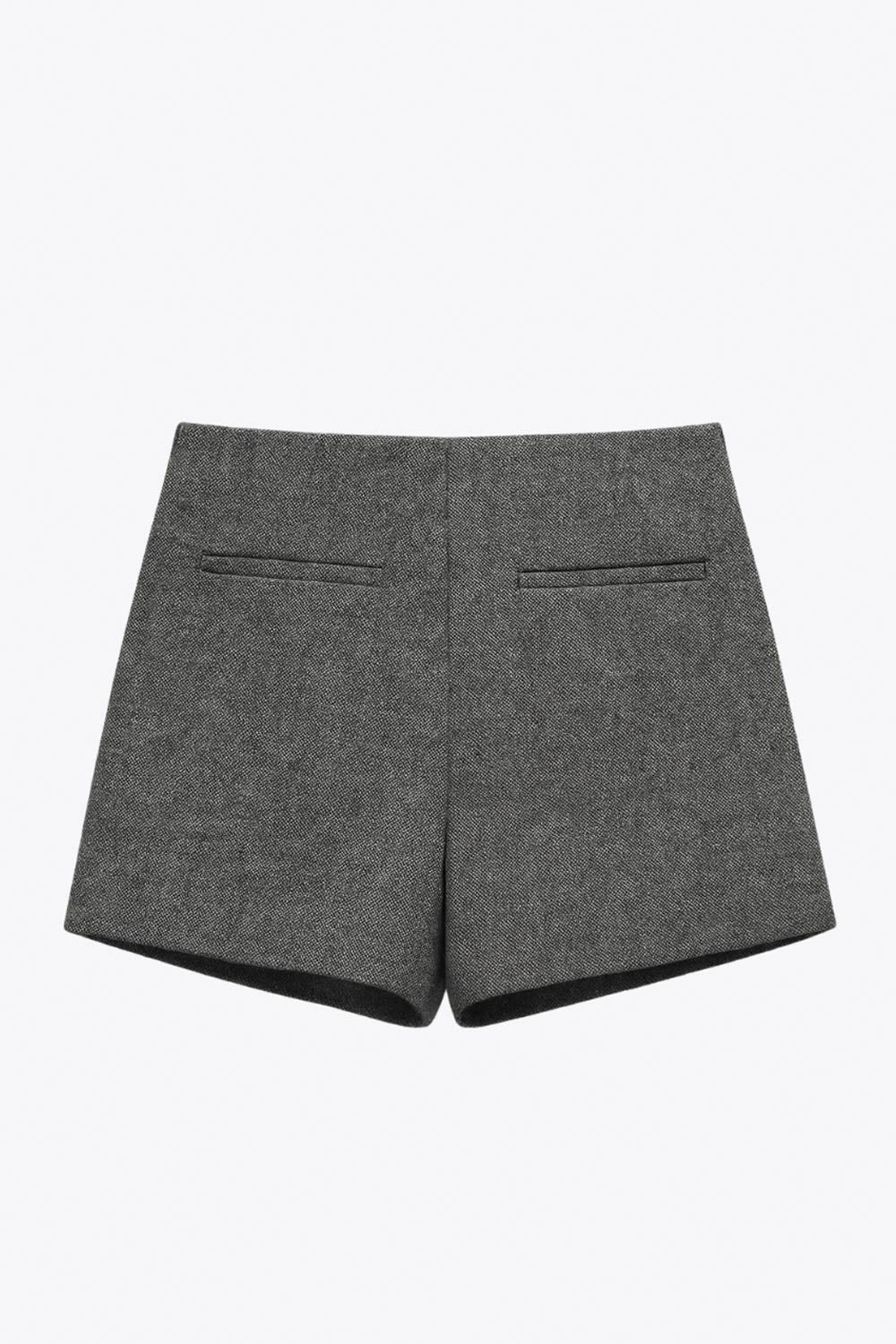 Falda short corto de fit ajustado, cintura alta, vivos decorativos posteriores y cierre lateral con cremallera oculta.