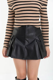 Falda short corto cargo, de efecto piel, cintura alta con pretina, corte en a, bolsillos laterales cargo con cartera, tableado frontal y posterior. Cierre frontal con botón en contraste y cremallera oculta.