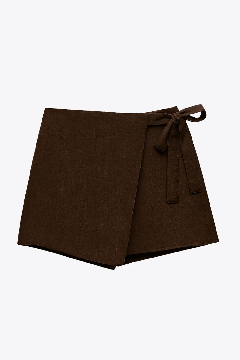 Falda short corto de cintura alta, corte en a, sobrefalda con cruce frontal, lazo lateral amarrable y cierre posterior con cremallera oculta.