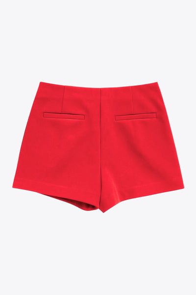 Falda short corto de fit ajustado, cintura alta, cruce frontal con bajo asimétrico, vivos decorativos posterior y cierre lateral con cremallera oculta.