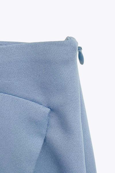 Falda short corto de fit ajustado, cintura alta, cruce frontal con bajo asimétrico, vivos decorativos posterior y cierre lateral con cremallera oculta.