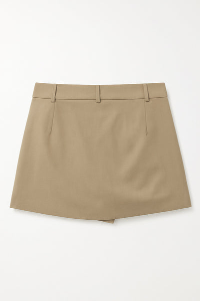 Falda short corto de cintura alta con pretina y trabillas, corte en a, cruce frontal en diagonal y vivos decorativos frontales. Cierre lateral con cremallera oculta.