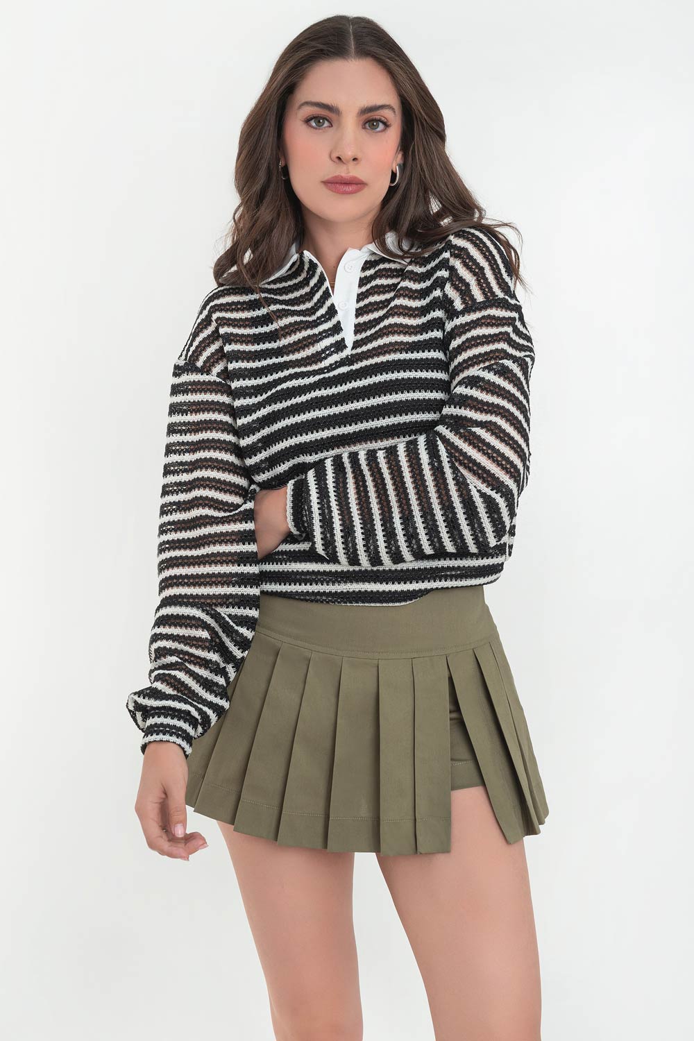 Falda short corto tableado, de cintura alta con pretina ancha, abertura frontal y cierre lateral con cremallera oculta.