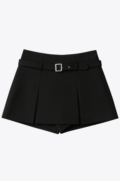 Falda short corto tableado, de cintura media, trabillas y cinturón con hebilla en contraste. Cierre lateral con cremallera oculta.