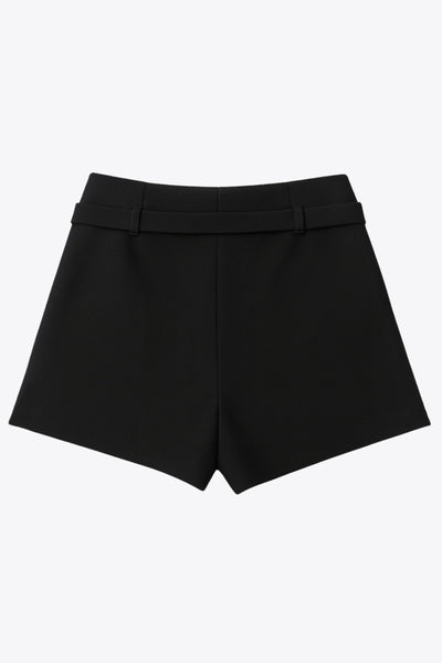 Falda short corto tableado, de cintura media, trabillas y cinturón con hebilla en contraste. Cierre lateral con cremallera oculta.