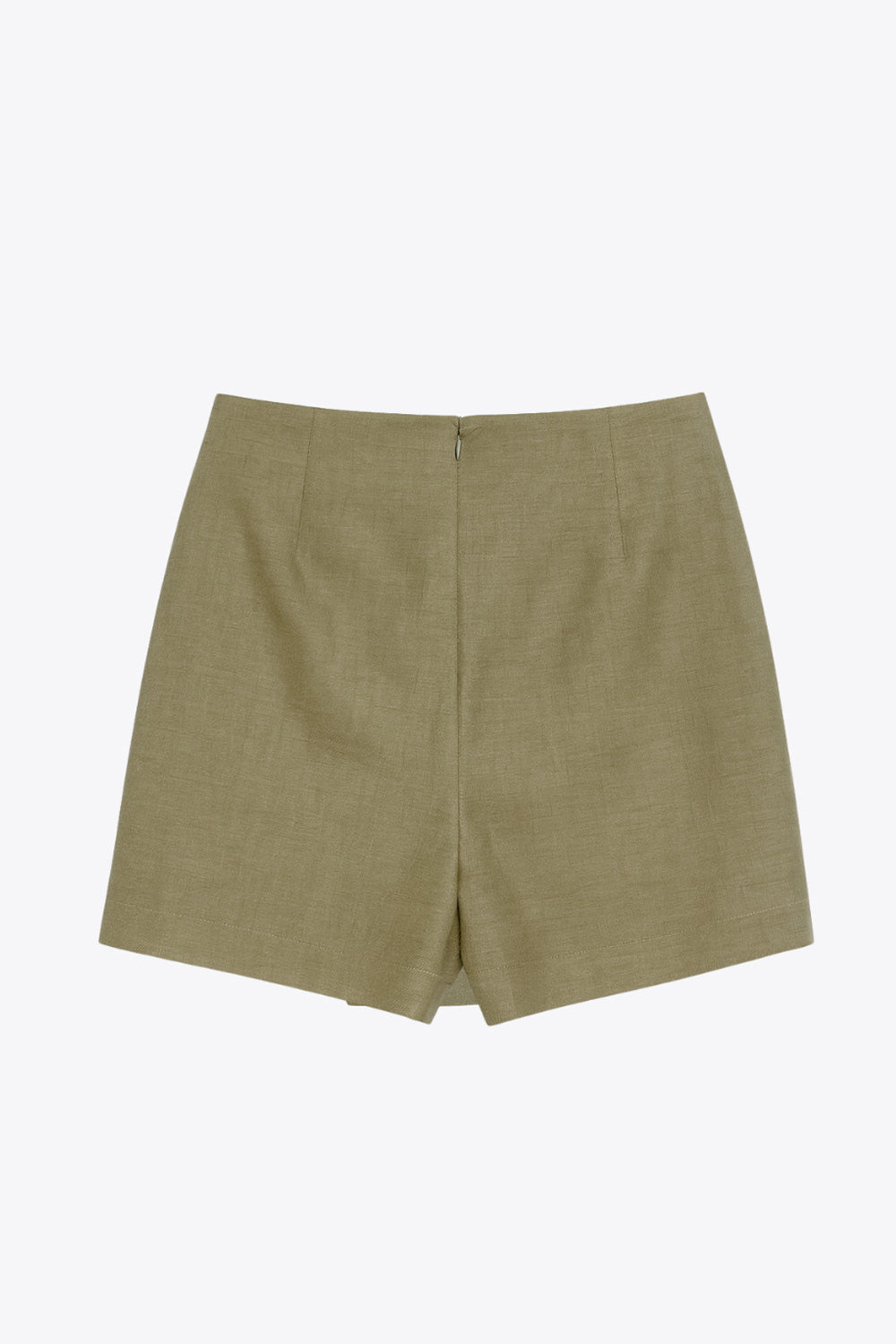 Falda short de fit ajustado, cintura alta, nudo frontal con plisados decorativos y bajo asimétrico. Cierre posterior con cremallera oculta.