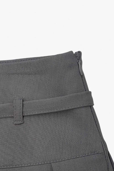 Falda short corto tableado, de corte en a, cintura alta con pretina, trabillas y lazo amarrable del tejido. Detalle de tableado en bajo y cierre lateral con cremallera oculta.