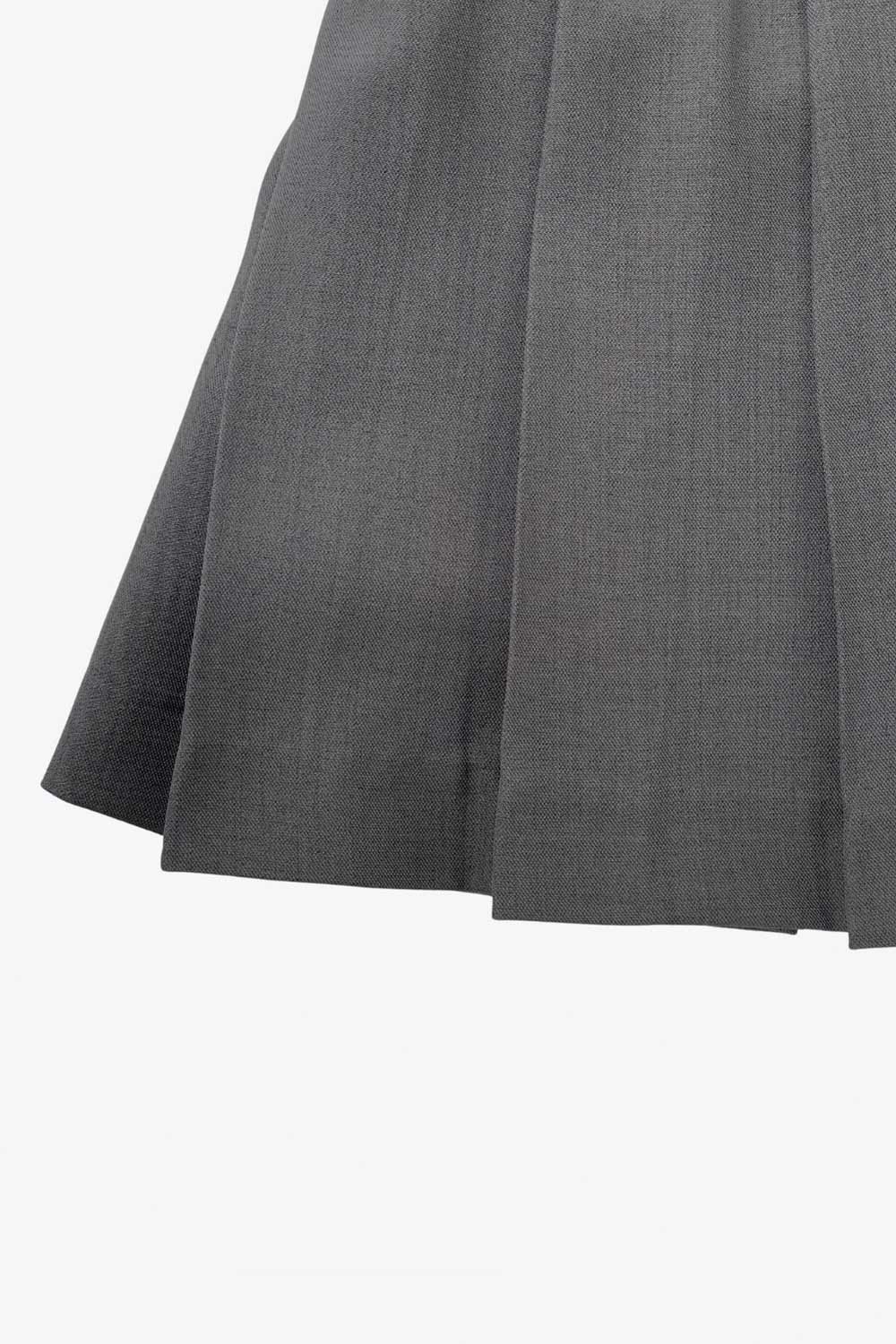 Falda short corto tableado, de corte en a, cintura alta con pretina, trabillas y lazo amarrable del tejido. Detalle de tableado en bajo y cierre lateral con cremallera oculta.