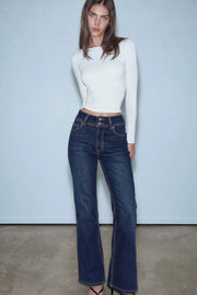 Pantalón de denim, fit flare, tiro medio, pretina con trabillas, bolsillos delanteros y traseros de parche con cartera. Cierre frontal con botones y cremallera oculta. Detalle de costuras en contraste.