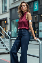 Pantalón de denim, fit wide leg, tiro alto, cintura alta con pretina y trabillas, bolsillos traseros de parche y cierre frontal con botones tipo marinero en contraste.