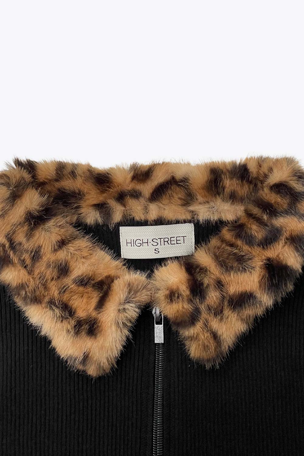 Jersey canalé de punto, fit ajustado, manga larga, cuello con solapa de efecto pelo y cierre frontal con cremallera.