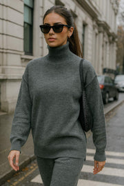Jersey de punto, fit oversized, cuello alto con rib, manga larga amplia con hombro caído, rib en bajo y puños. Detalle de costuras decorativas.