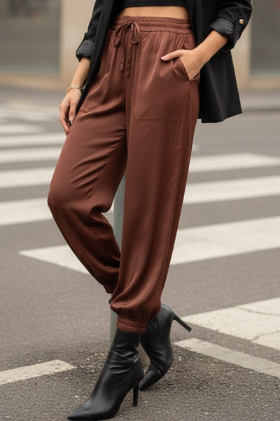 Pantalón jogger satinado de fit recto, bolsillos delanteros de parche, cintura alta con pretina elástica y jareta ajustable. Detalle de bajo elástico.