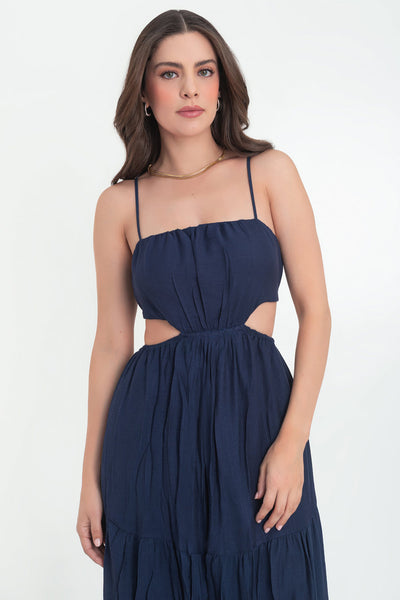 Maxi vestido de escote recto con plisados frontales, tirantes delgados ajustables, corte en a, bajo con capas de olanes, cut out en costados y espalda. Detalle de rib elástico en cintura.