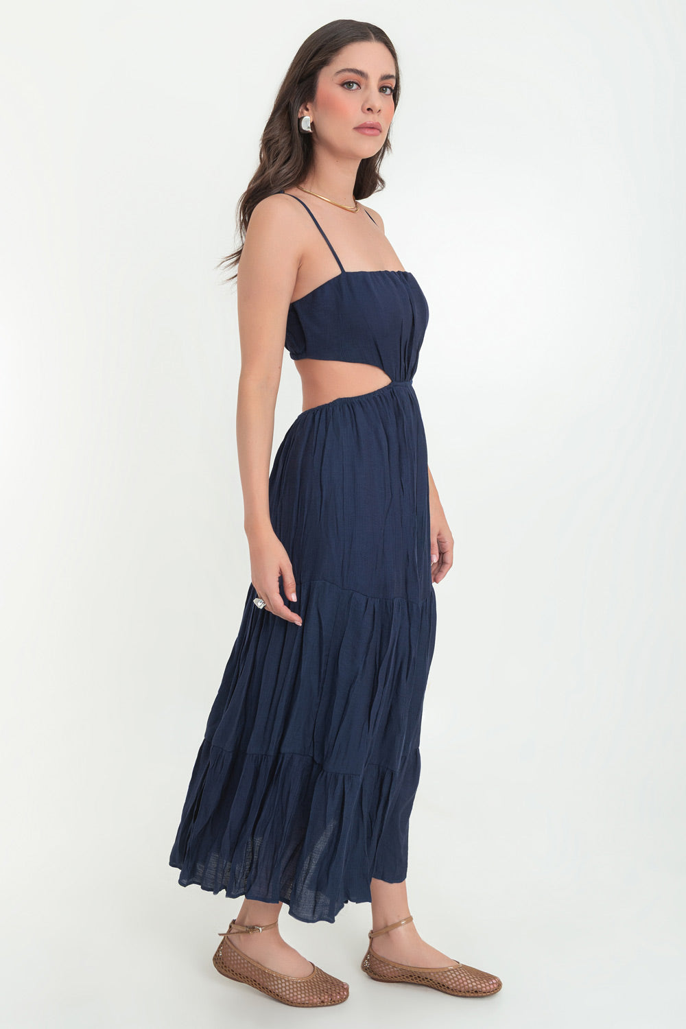 Maxi vestido de escote recto con plisados frontales, tirantes delgados ajustables, corte en a, bajo con capas de olanes, cut out en costados y espalda. Detalle de rib elástico en cintura.