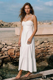 Maxi vestido de corte en a, tirantes delgados con nudo amarrable, escote corazón con cortes y detalles plisados. Cierre posterior con cremallera visible en contraste y olanes en borde de bajo.