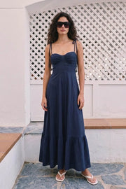 Maxi vestido de corte en a, tirantes delgados con nudo amarrable, escote corazón con cortes y detalles plisados. Cierre posterior con cremallera visible en contraste y olanes en borde de bajo.