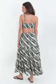 Maxi vestido estampado de corte en a, tirantes delgados ajustables, bajo con capas de olanes, cut out en costados y espalda. Detalle de rib elástico en cintura y cierre lateral con cremallera oculta.