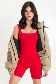 Mono corto de fit ajustado, sin mangas, cuello barco y corte en cintura.