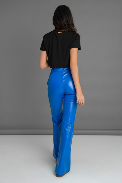 Pantalón ajustado de efecto piel, fit flare, bolsillos delanteros, cintura alta con pretina y trabillas. Cierre frontal con botón en contraste y cremallera oculta.