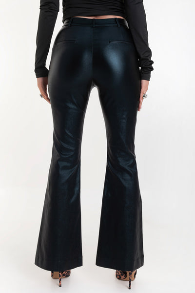 Pantalón ajustado de fit flare, efecto piel, cintura media con pretina y trabillas, bolsillos delanteros y vivos decorativos posteriores. Cierre frontal con broche y cremallera ocultos.