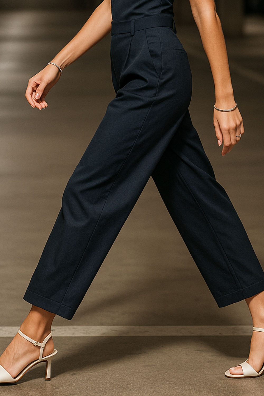 Pantalón de fit wide leg, pinzas frontales, cintura alta con pretina y trabillas, bolsillos delanteros y vivos decorativos traseros. Cierre frontal con broche y cremallera ocultos.