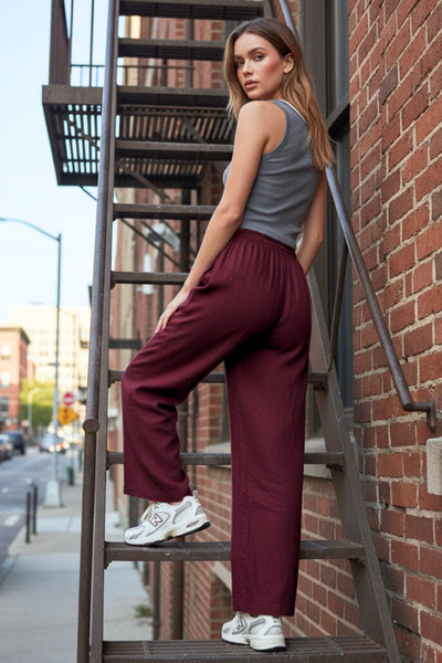 Pantalón fluido de fit wide leg, bolsillos delanteros y cintura alta con pretina elástica.