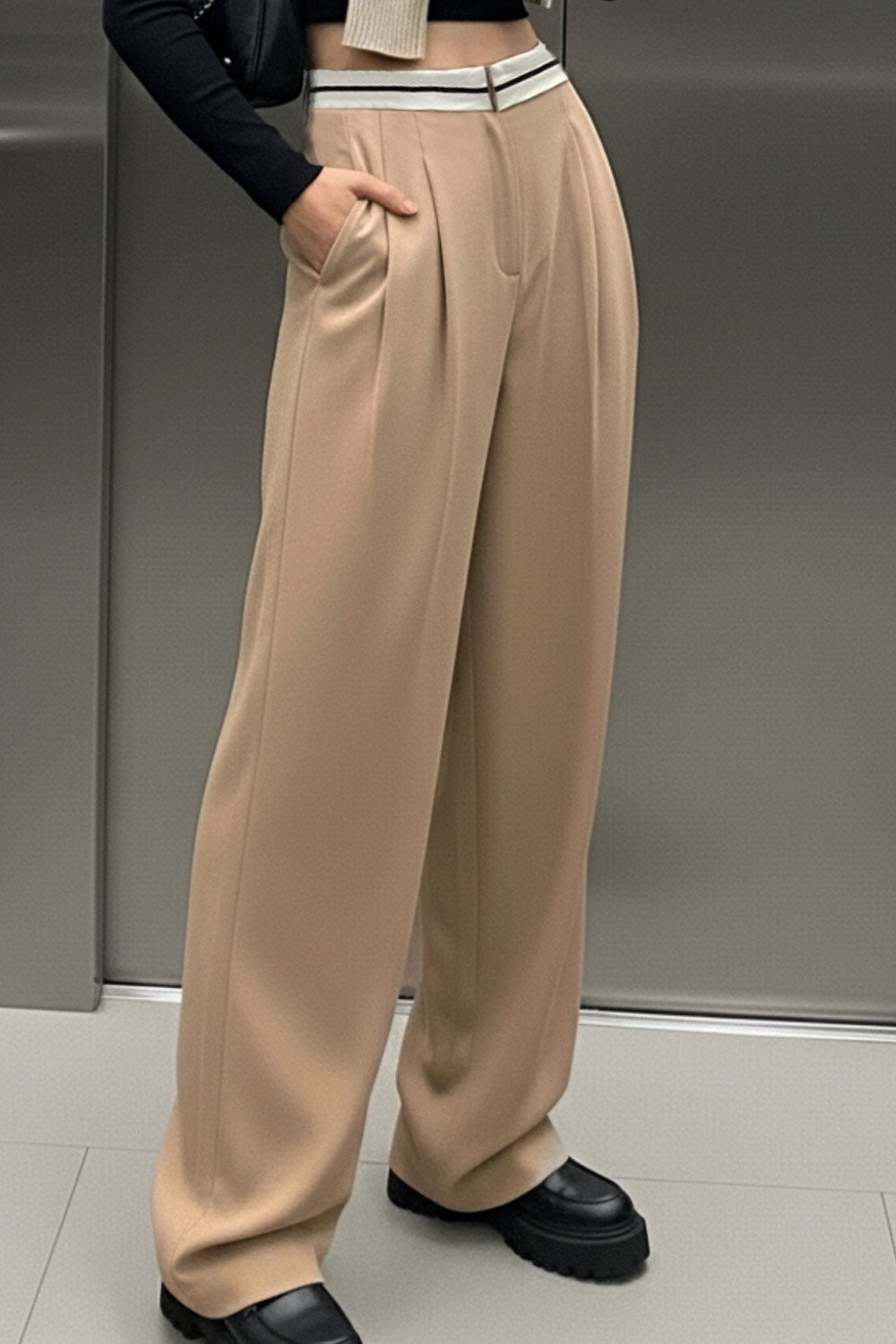 Pantalón de fit wide leg, pinzas frontales, cintura media con detalle de pretina en contraste, bolsillos delanteros y vivos decorativos posteriores. Detalle de raya frontal y posterior. Cierre frontal con broche y cremallera ocultos.