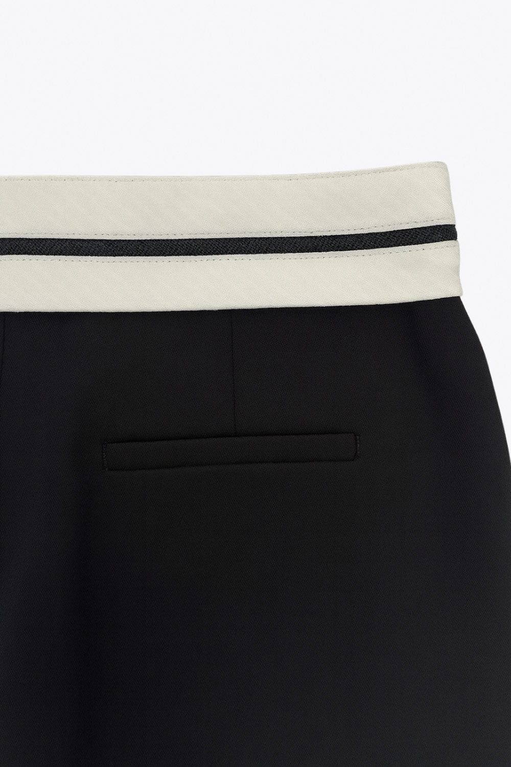 Pantalón de fit wide leg, pinzas frontales, cintura media con detalle de pretina en contraste, bolsillos delanteros y vivos decorativos posteriores. Detalle de raya frontal y posterior. Cierre frontal con broche y cremallera ocultos.