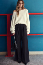 Pantalón de fit palazzo, cintura alta con trabillas, pinzas frontales, bolsillos delanteros y vivos decorativos posteriores, raya frontal y posterior. Cierre frontal con broche y cremallera ocultos.