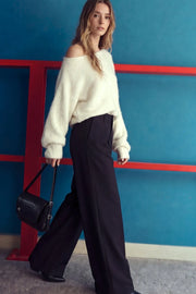 Pantalón de fit palazzo, cintura alta con trabillas, pinzas frontales, bolsillos delanteros y vivos decorativos posteriores, raya frontal y posterior. Cierre frontal con broche y cremallera ocultos.