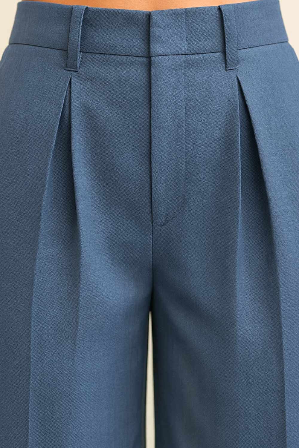 Pantalón de fit palazzo, cintura alta con trabillas, pinzas frontales, bolsillos delanteros y vivos decorativos posteriores, raya frontal y posterior. Cierre frontal con broche y cremallera ocultos.