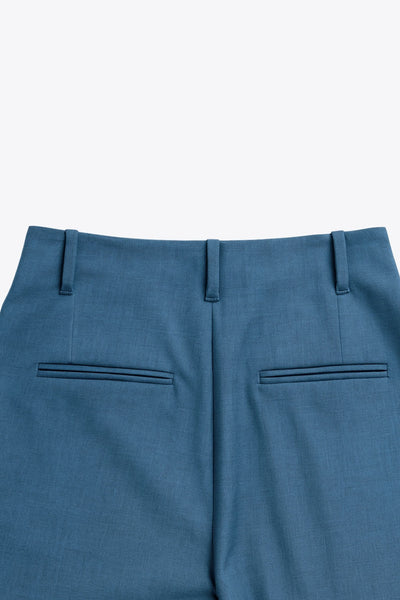 Pantalón de fit palazzo, cintura alta con trabillas, pinzas frontales, bolsillos delanteros y vivos decorativos posteriores, raya frontal y posterior. Cierre frontal con broche y cremallera ocultos.