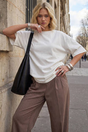 Pantalón fluido de fit wide leg, estampado rayas, cintura alta con pretina elástica posterior, trabillas, pinzas frontales y bolsillos delanteros.