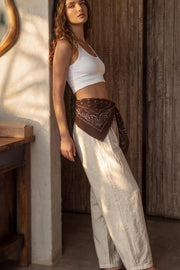 Pantalón de lino, fit balloon, pinzas con cortes frontales, cintura alta con pretina elástica y jareta frontal ajustable, bolsillos delanteros y pinzas en bajo.